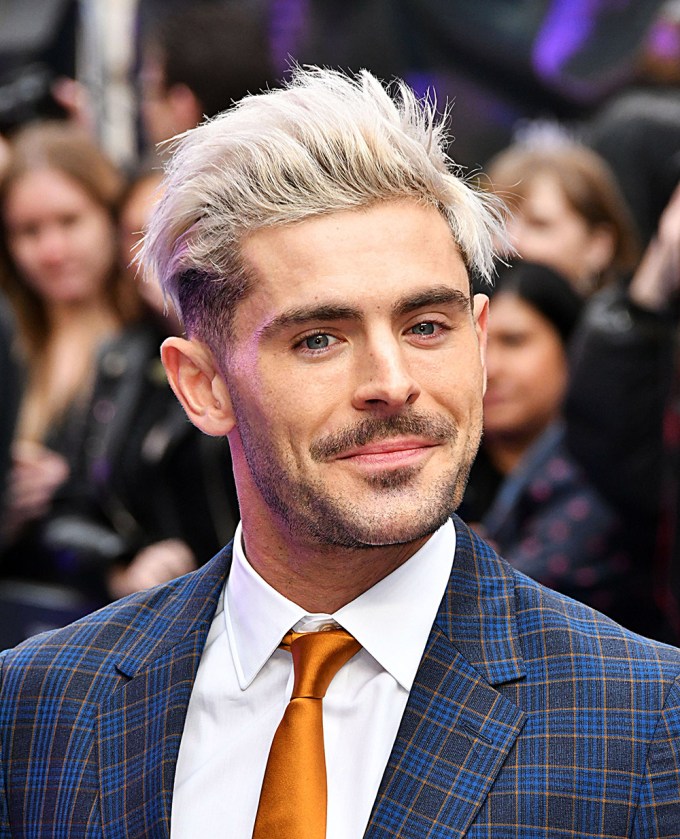 Zac Efron smiles at an event