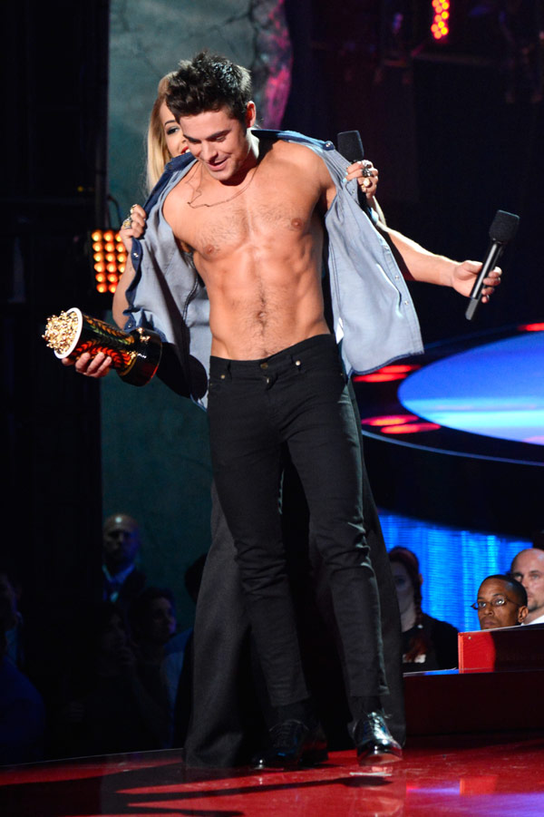 Zac Efron helps Zac Efron out of his shirt at the MTV Movie Awards