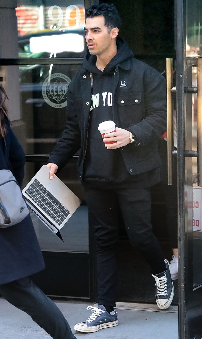 Joe Jonas out getting coffee and working on his laptop