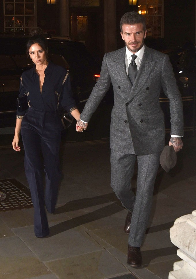 Victoria Beckham and David Beckham hold hands