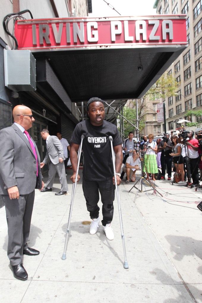Troy Ave walks on crutches