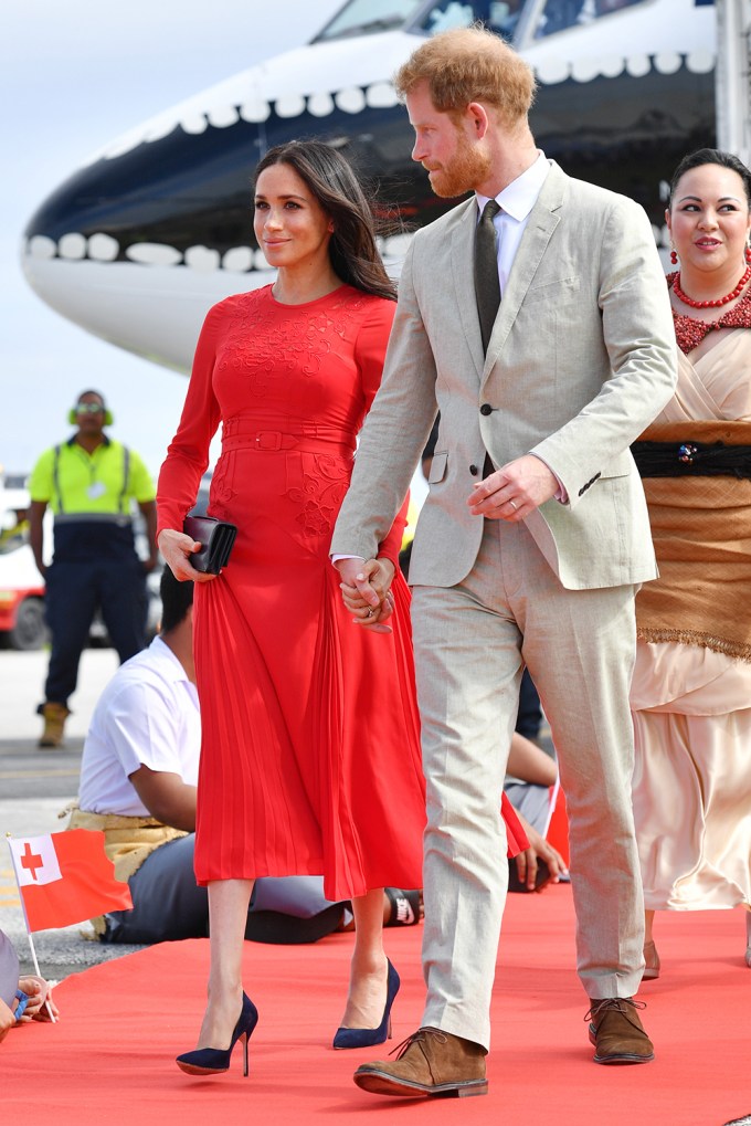 Prince Harry and Meghan Markle hold hands at Fua’amotu Airport