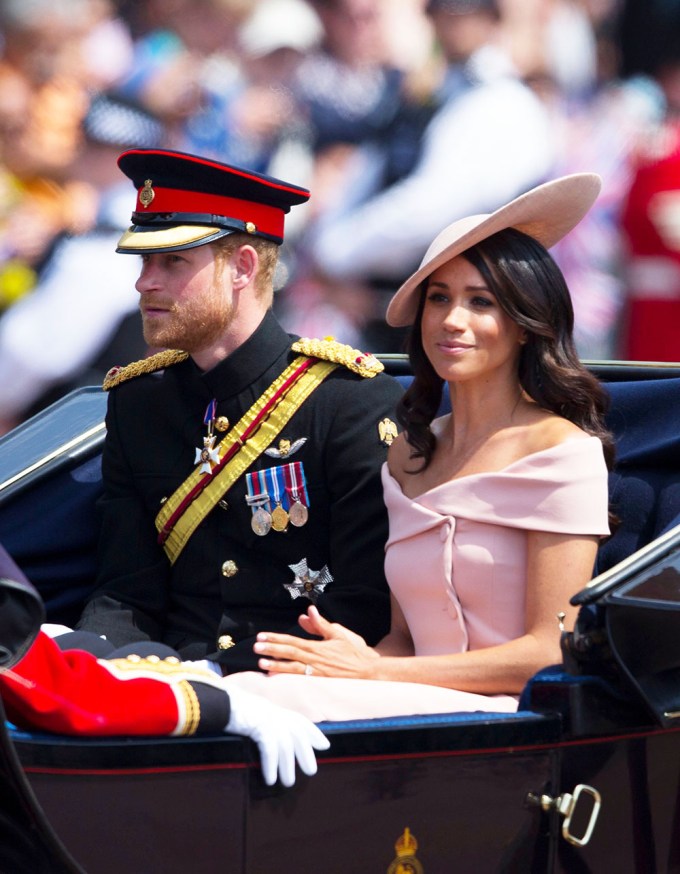 Meghan Markle & Prince Harry look out over the outside crowd
