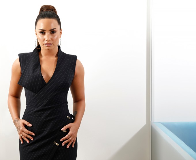 Demi Lovato poses in a black dress