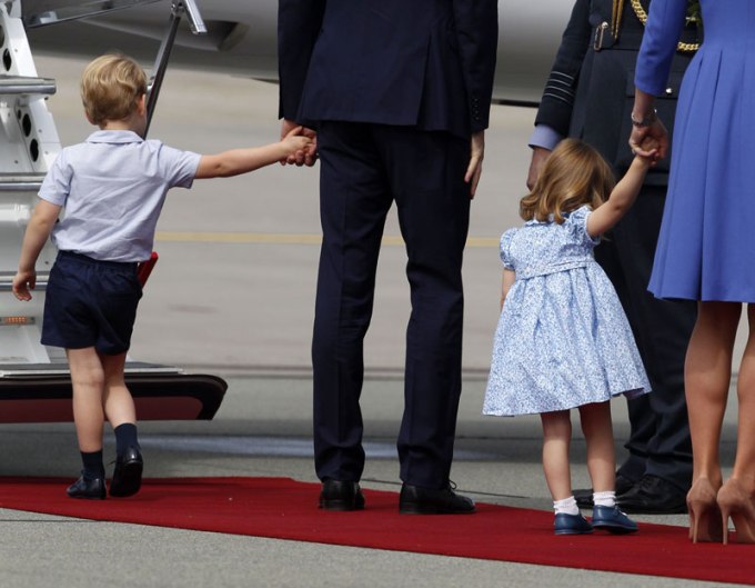 Prince George and Princess Charlotte holding their parents’ hands