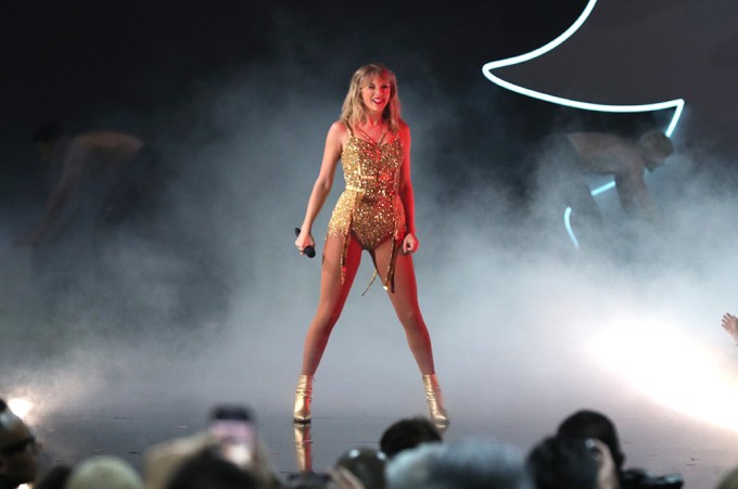 T Swift Embracing Power Clad In Gold