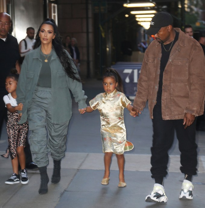 Kim Kardashian & Kanye West hold North’s hand in New York
