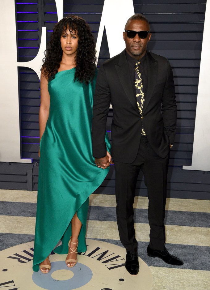 Idris Elba & Sabrina Dhowre pose at an event