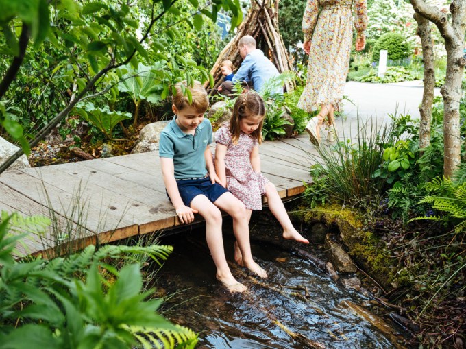 Prince George and Princess Charlotte dip their bare feet in a creek.