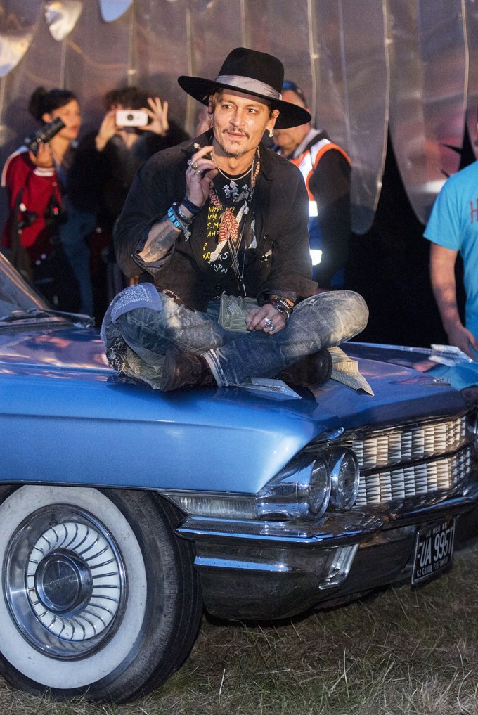 Johnny Depp sits on a car
