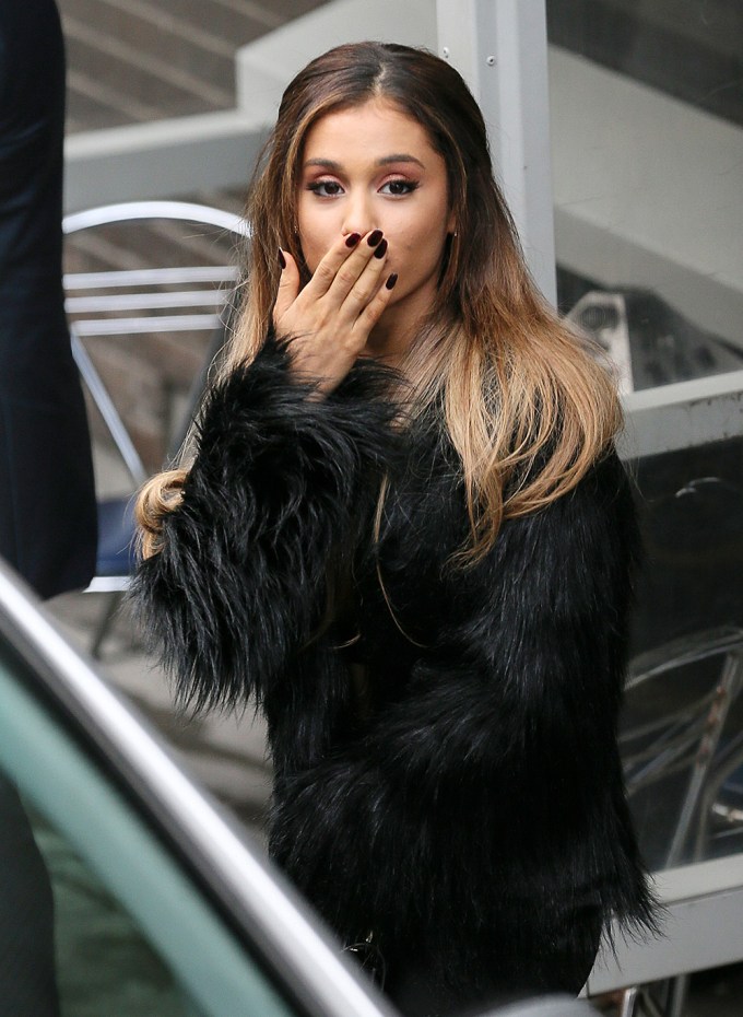 Ariana Grande blows kisses to fans with her hair down and straight