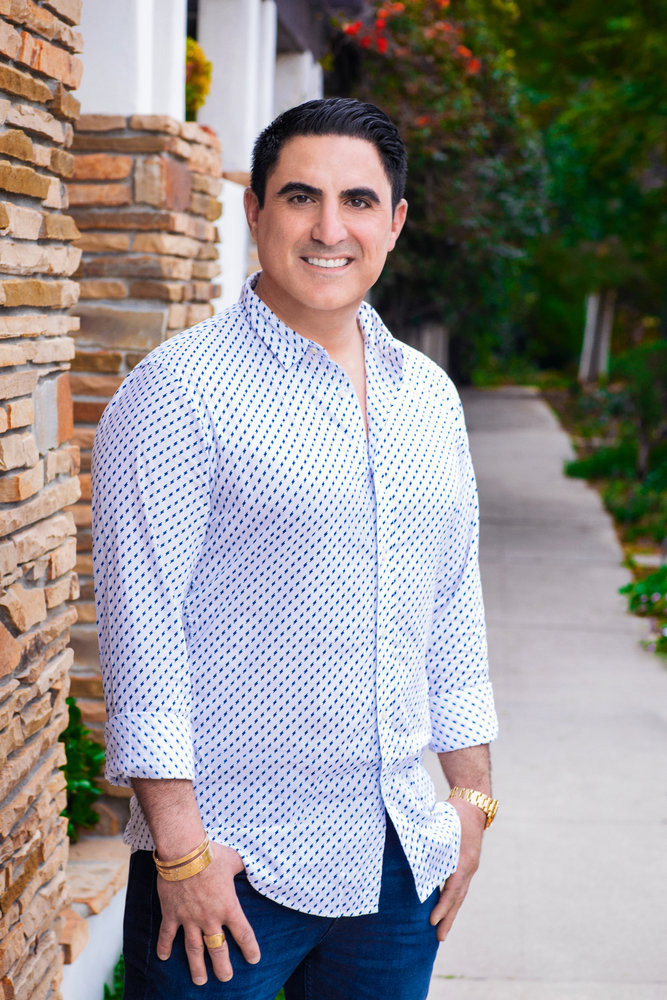 Reza Farahan poses in a blue and white shirt