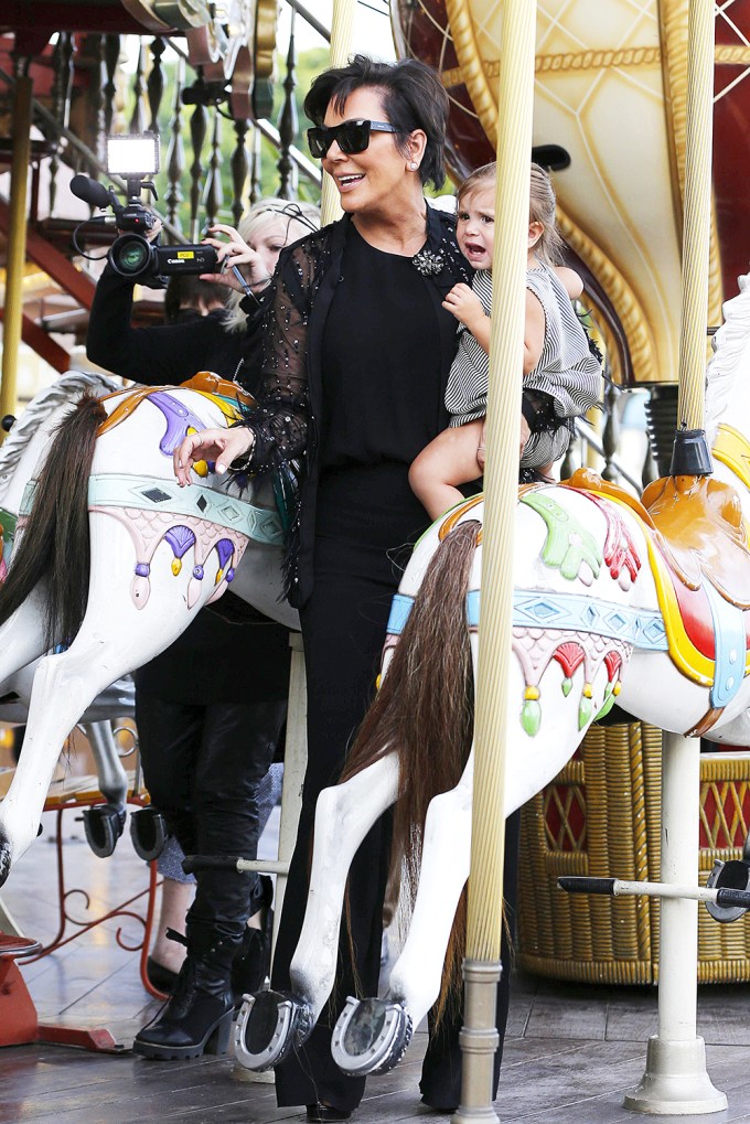 Kris Jenner with Penelope Disick on a carousel