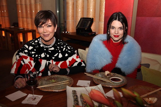 Kris Jenner and Kendall Jenner smiling while sitting down