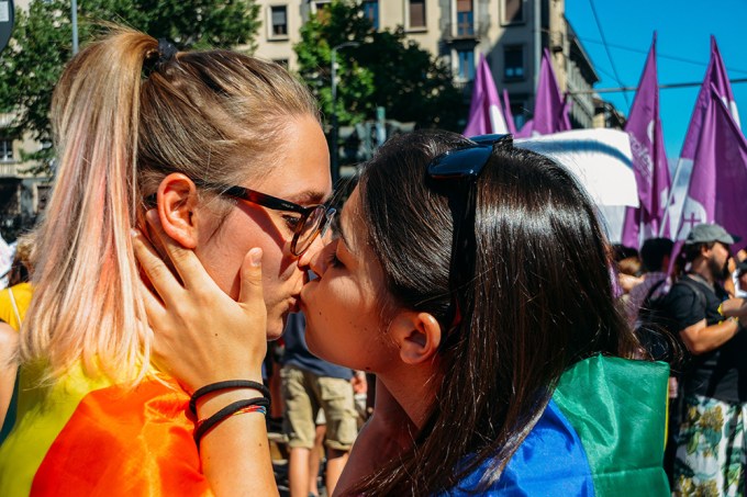 Two Women Kiss During A Pride Parade