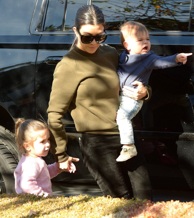 Kourtney Kardashian holds her daughter Penelope’s hand and her son Reign on an outing