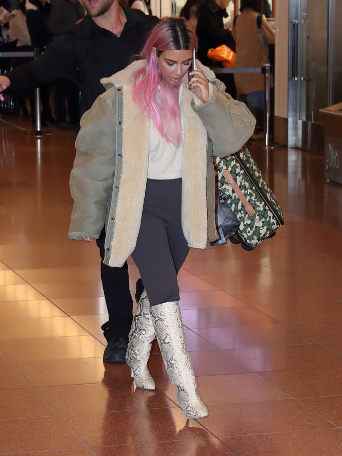 Kim Kardashian looked down at her snakeskin boots while walking