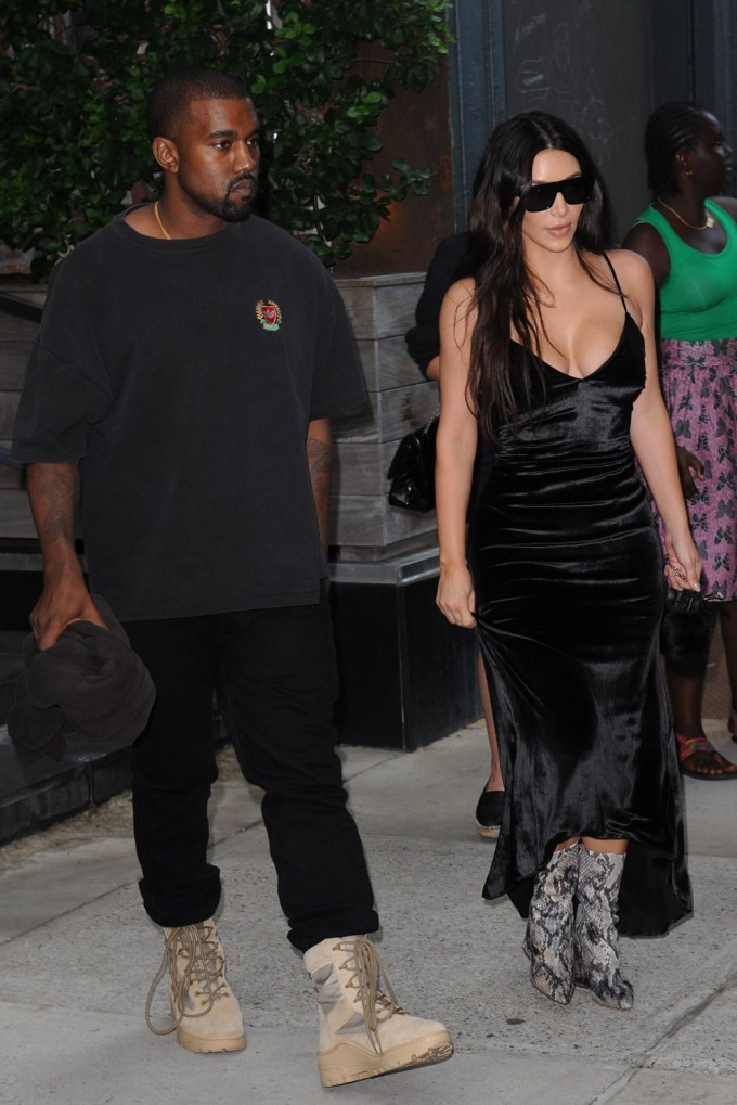 Kanye West and Kim Kardashian walking as she wears snakeskin boots