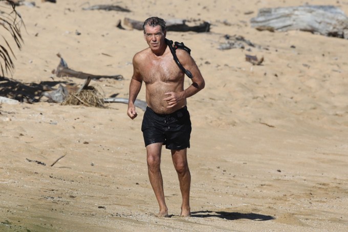 Pierce Brosnan walking on sand