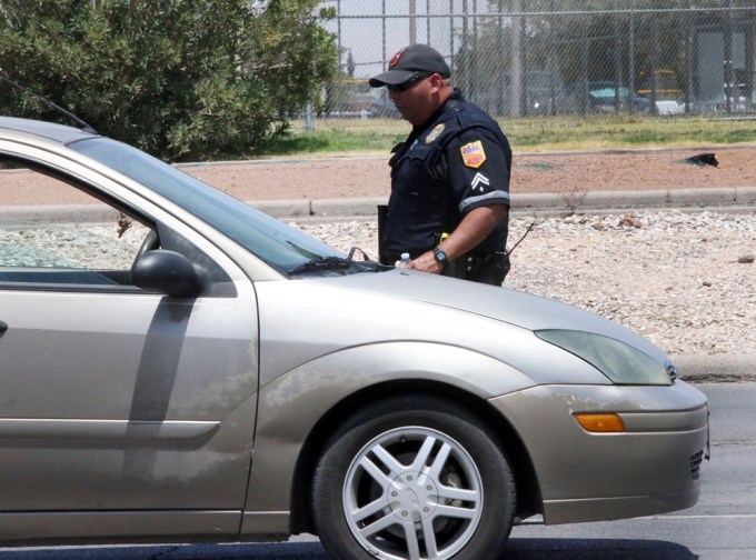 An officer checks vehicles at the Walmart shooting scene