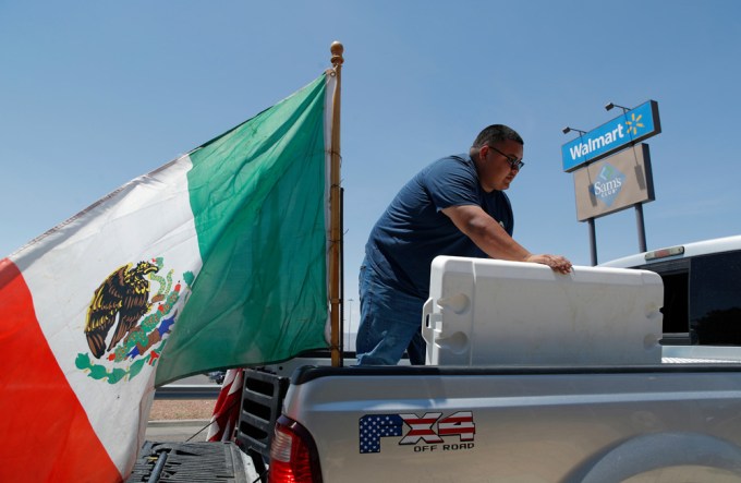 A man gives water to mourners at the El Paso Walmart massacre