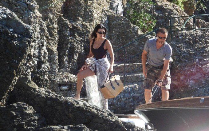 Kourtney Kardashian walking on some rocks in Italy