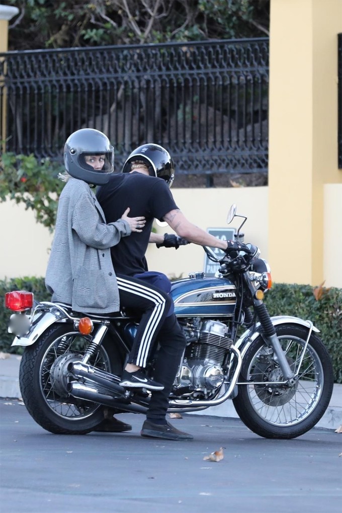 Miley Cyrus rides on the back of Cody Simpson’s motorcycle