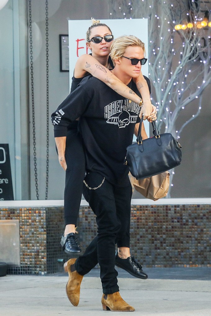 Cody Simpson carries Miley Cyrus