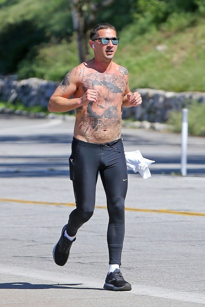Shia LaBeouf goes for a jog while showing off his heavily tattooed chest