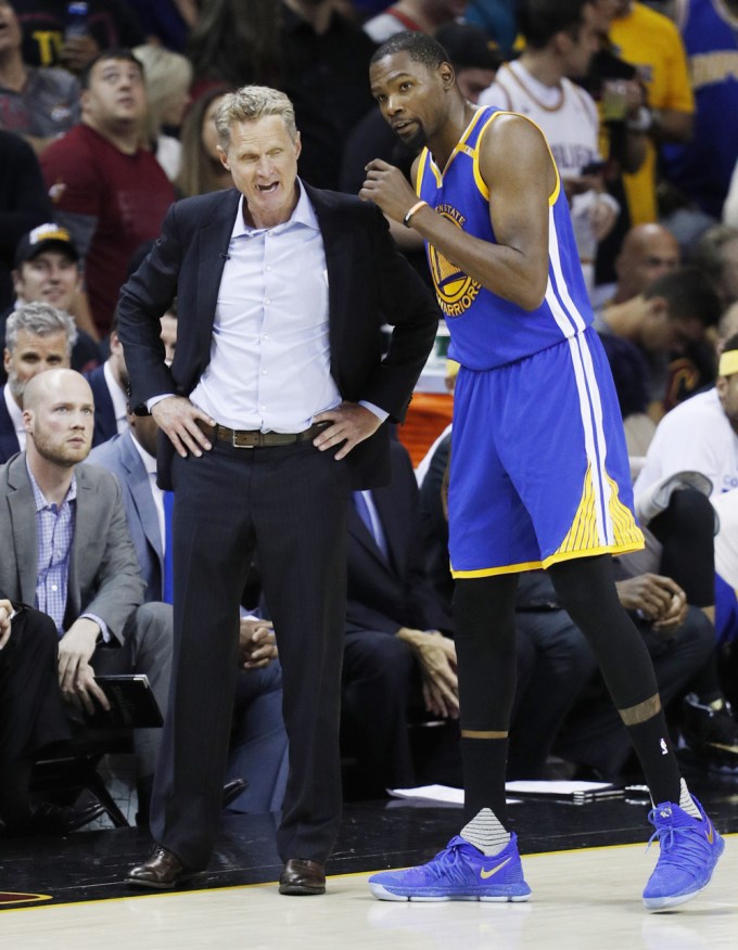 Steve Kerr talks with Kevin Durant during a basketball game