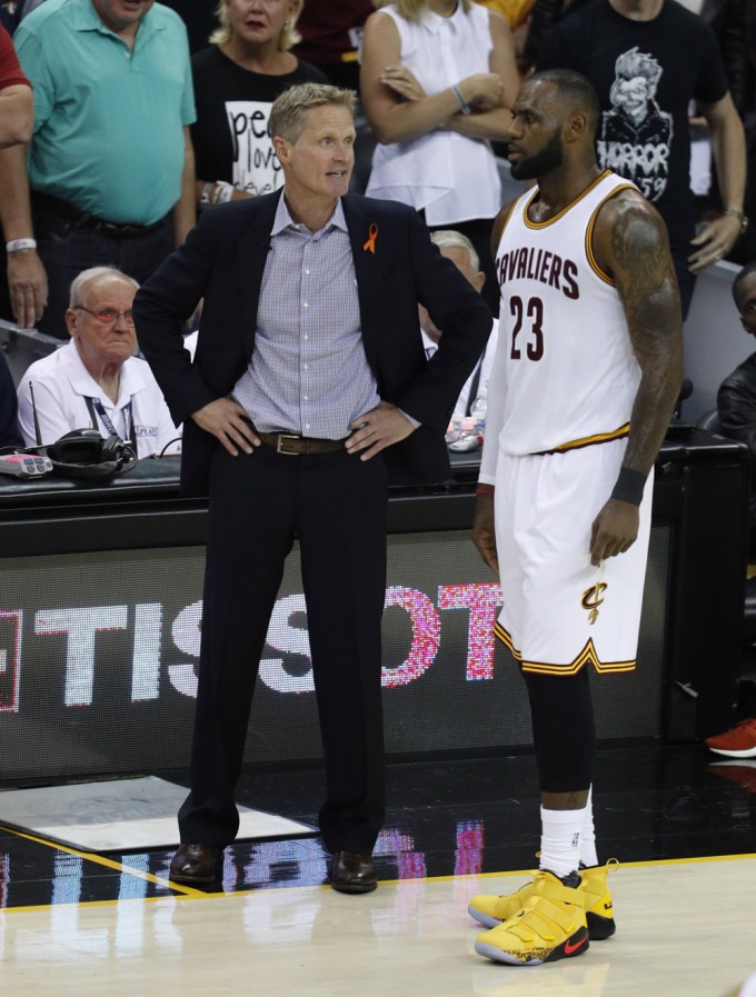 Steve Kerr and LeBron James talk at a basketball game
