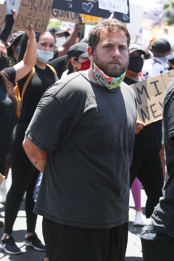Jonah Hill gives a serious look while protesting
