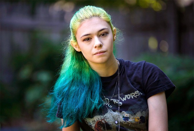 Nicole Maines rocks rainbow colored hair and a vintage t-shirt.