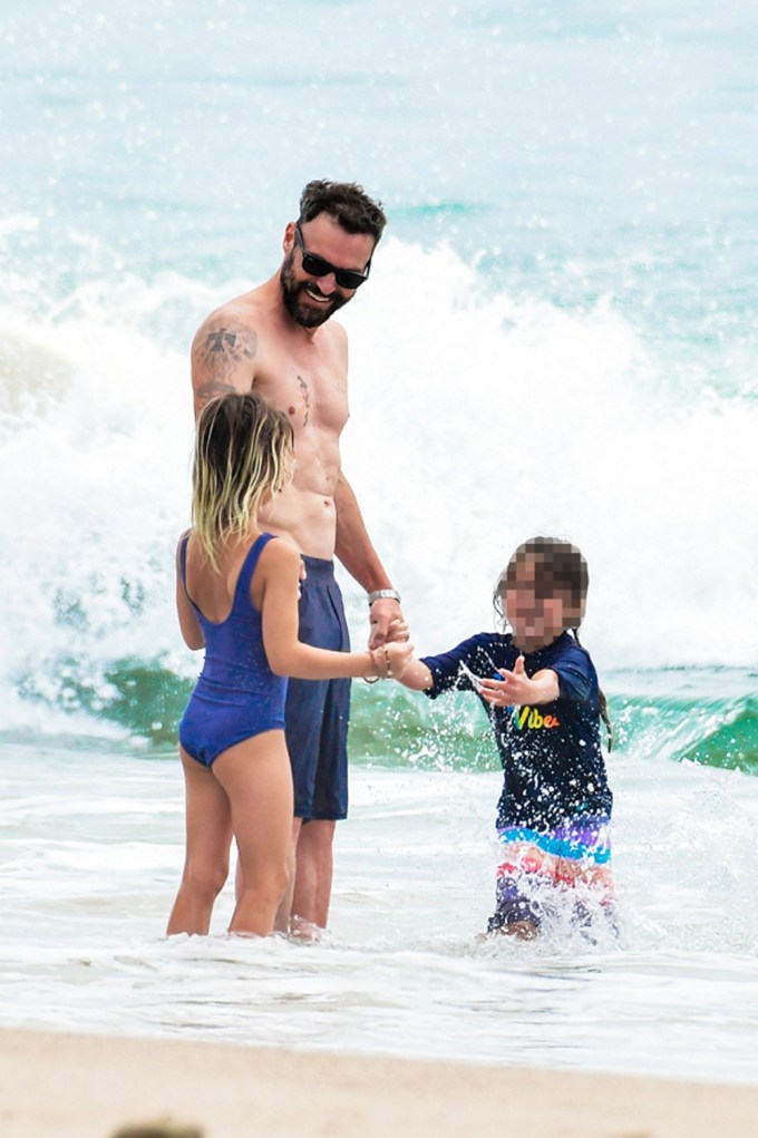 Brian Austin Green plays in the surf with his kids