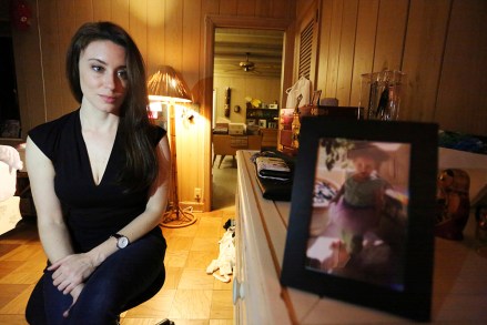 In this Feb.  13, 2017 photo, Casey Anthony poses for a portrait next to a photo of her daughter, Caylee, in her West Palm Beach, Fla., bedroom.  In an exclusive interview with The Associated Press, Anthony claims the last time she saw Caylee she 