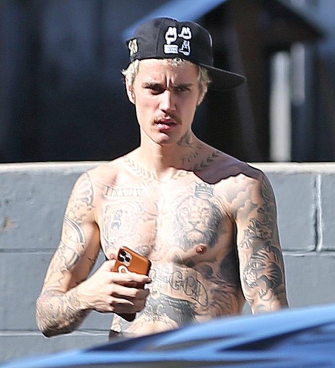 Justin Bieber goes shirtless while showing off his tattoos