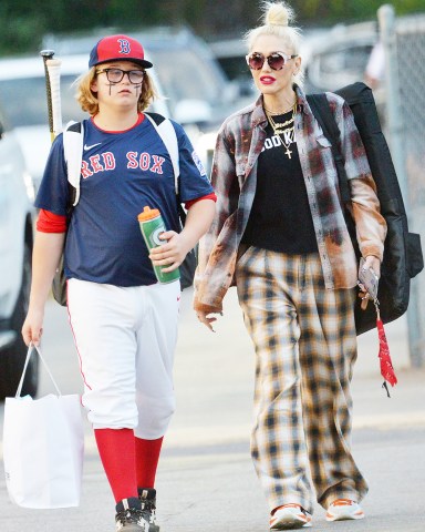 EXCLUSIVE: Gwen Stefani wears her flannel pajamas, a flannel shirt, and a t-shirt that reads Good Karma to Zuma's baseball game in L.A. on Thursday. Blake Shelton did not attend the game. Gwen was drinking coconut water throughout the game while talking to other parents in the stands. 26 May 2022 Pictured: Gwen Stefani wears flannel pajamas to Zuma's baseball game. Photo credit: GP/ MEGA TheMegaAgency.com +1 888 505 6342 (Mega Agency TagID: MEGA862469_016.jpg) [Photo via Mega Agency]