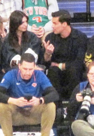 EXCLUSIVE: Emily Ratajkowski chats with a mystery man in her vip courtside seat as she sips on a beverage and stares at him at the Knicks Game inside Madison Square Garden in New York City.  The model was very animated as she sat with the man as they talked closely for the entire game and left together inside the arena as she wore a small crop top and Keith Harring art jacket.  11 Jan 2023 Pictured: Emily Ratajkowski, mystery man.  Photo credit: Brian Prahl/MEGA TheMegaAgency.com +1 888 505 6342 (Mega Agency TagID: MEGA932055_025.jpg) [Photo via Mega Agency]