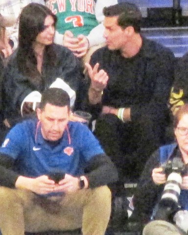 EXCLUSIVE: Emily Ratajkowski chats with a mystery man in her vip courtside seat as she sips on a beverage and stares at him at Knicks Game inside Madison Square Garden in New York City. The model was very annimated as she sat with the man as they talked closely for the entire game and left together inside the arena as she wore a small crop top and Keith Harring art jacket. 11 Jan 2023 Pictured: Emily Ratajkowski, mystery man. Photo credit: Brian Prahl/MEGA TheMegaAgency.com +1 888 505 6342 (Mega Agency TagID: MEGA932055_025.jpg) [Photo via Mega Agency]