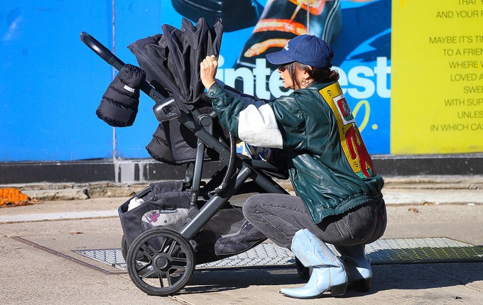 Emily Ratajkowski fixing her son’s stroller