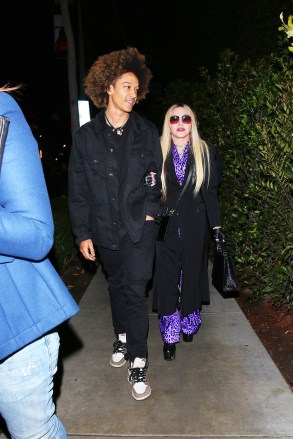 Los Angeles, CA - *EXCLUSIVE* - Madonna and her boyfriend Ahlamalik Williams and her son, David Banda, arrive at Cecconi's for a late dinner. Madonna reportedly arrived around 12:30 am and had the place to herself. The pop superstar stepped out in a purple satin pajama style pant outfit with a. leopard print. She topped the look with a black coat and accessorized with a pair of leather fingerless gloves and a black crocodile Hermes bag blinged out in diamond studs spelling the word, DEALER. Madonna, 63 held on to her 27 year boyfriend, Ahlamalik Williams apparently to steady herself in a pair of platforms boots.Pictured: Ahlamalik Williams, MadonnaBACKGRID USA 20 JANUARY 2022 USA: +1 310 798 9111 / usasales@backgrid.comUK: +44 208 344 2007 / uksales@backgrid.com*UK Clients - Pictures Containing ChildrenPlease Pixelate Face Prior To Publication*