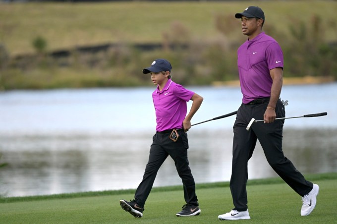 Tiger Woods and his son Charlie walking on a golf course