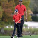 Tiger Woods and his son Charlie line up a putt on the 18th green during the final round of the PNC Championship golf tournament, Sunday, Dec. 20, 2020, in Orlando, Fla. (AP Photo/Phelan M. Ebenhack)