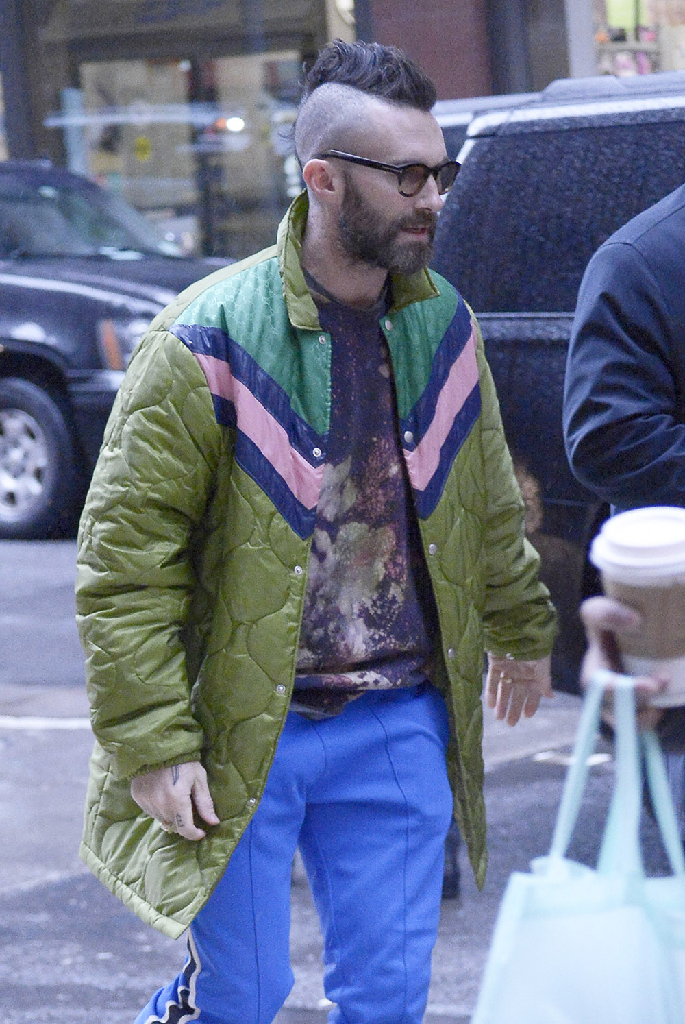 Adam Levine Wears A Colorful Green Jacket Coat, Blue Pants And Nike Sneakers At The NBC Upfronts In NYC