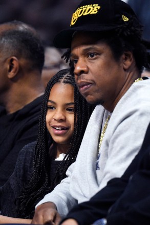 Rapper Jay-Z, right, sits with his daughter Blue Ivy during the second half of an NBA basketball game between the Los Angeles and the Los Angeles Lakers Sunday, March 8, 2020, in Los Angeles. The Lakers won 112-103. (AP Photo/Mark J. Terrill)