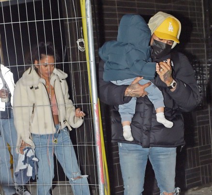 London, UNITED KINGDOM - *EXCLUSIVE* - R&B star Chris Brown plays the doting father, as he holds his baby son Aeko with baby mother Ammika Harris following behind, holding a baby bottle.  Chris looked casual wearing his North Face jacket, yellow cap, jeans and his protective face mask as he showed off some bling with his flash designer watch.  The British singer Rita Ora was also spotted looking a little inconspicuous wearing her black PVC puffer jacket and designer Chanel handbag trying to hide from the cameras and also showing off her wealth, with her hands full of gold rings on each finger as the gang left separately. from a venue in London's Soho.  Pictured: Chris Brown - Ammika Harris BACKGRID USA 14 OCTOBER 2020 BYLINE MUST READ: SOUTHPAW / BACKGRID USA: +1 310 798 9111 / usasales@backgrid.com UK: +44 208 344 2007 / uksales@backgrid.com *UK Clients - Pictures Containing Children Please Pixelate Face Prior To Publication*