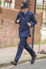 Harry Styles dressed in a 1950's British policeman costume runs down the street with David Dawson as they film My Policeman in Brighton. 14 May 2021 Pictured: Harry Styles dressing as a 1950's British policeman runs down the street with David Dawson as they film My Policeman in Brighton. Photo credit: DC/MEGA TheMegaAgency.com +1 888 505 6342 (Mega Agency TagID: MEGA754434_001.jpg) [Photo via Mega Agency]