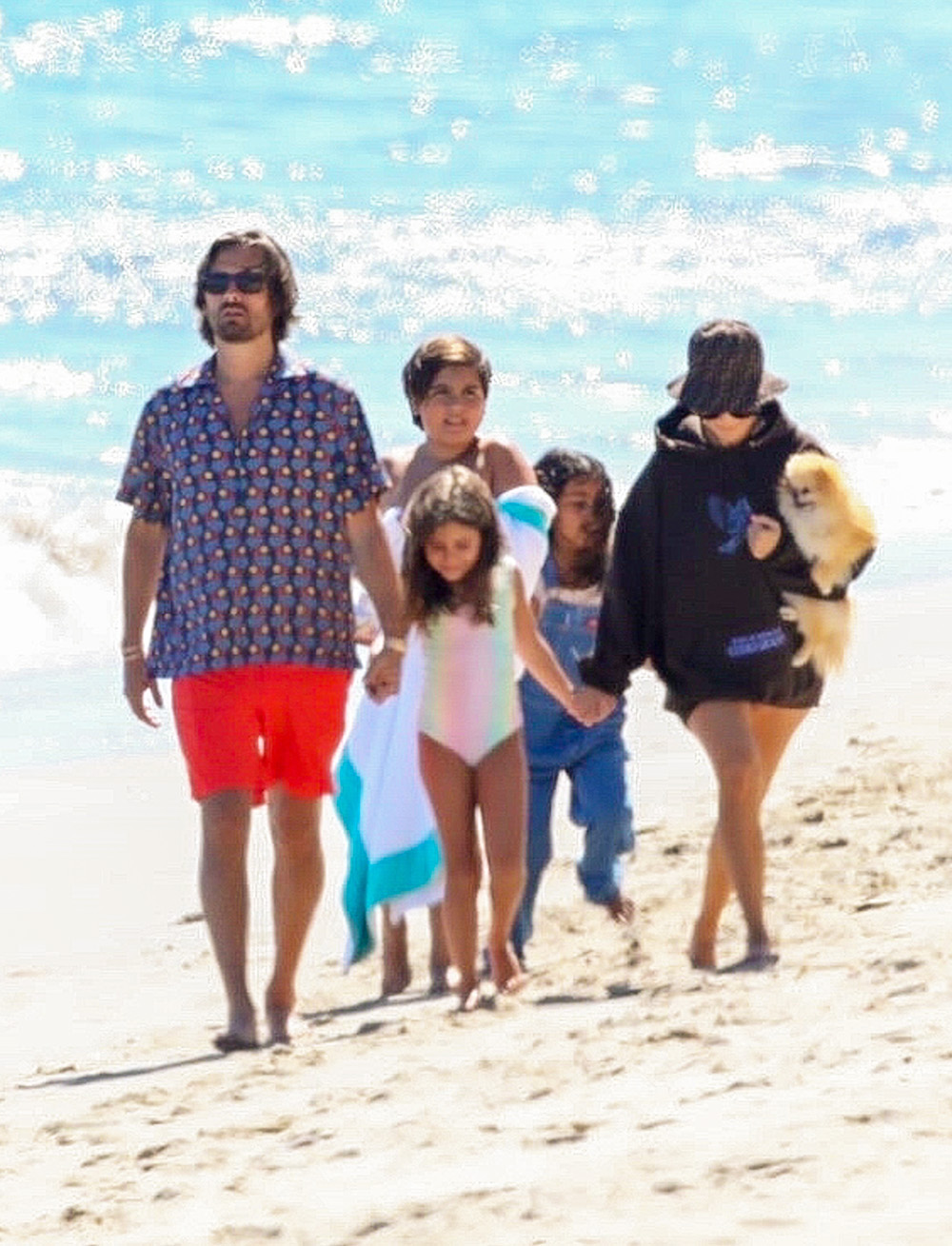 Kourtney Kardashian and Scott Disick go for a walk on the beach with their brood and friend Luka Sabbat