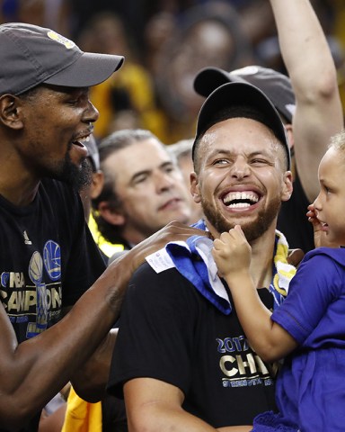 Kevin Durant and Stephen Curry
Cleveland Cavaliers at Golden State Warriors, Oakland, USA - 12 Jun 2017
Golden State Warriors player Kevin Durant (L) laughs with teammate Stephen Curry (C) holding one of his daughters while celebrating after winning the NBA Finals against the Cleveland Cavaliers in game five of the NBA Finals.