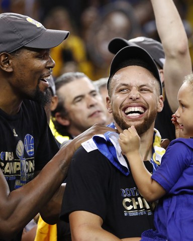 Kevin Durant and Stephen Curry
Cleveland Cavaliers at Golden State Warriors, Oakland, USA - 12 Jun 2017
Golden State Warriors player Kevin Durant (L) laughs with teammate Stephen Curry (C) holding one of his daughters while celebrating after winning the NBA Finals against the Cleveland Cavaliers in game five of the NBA Finals.